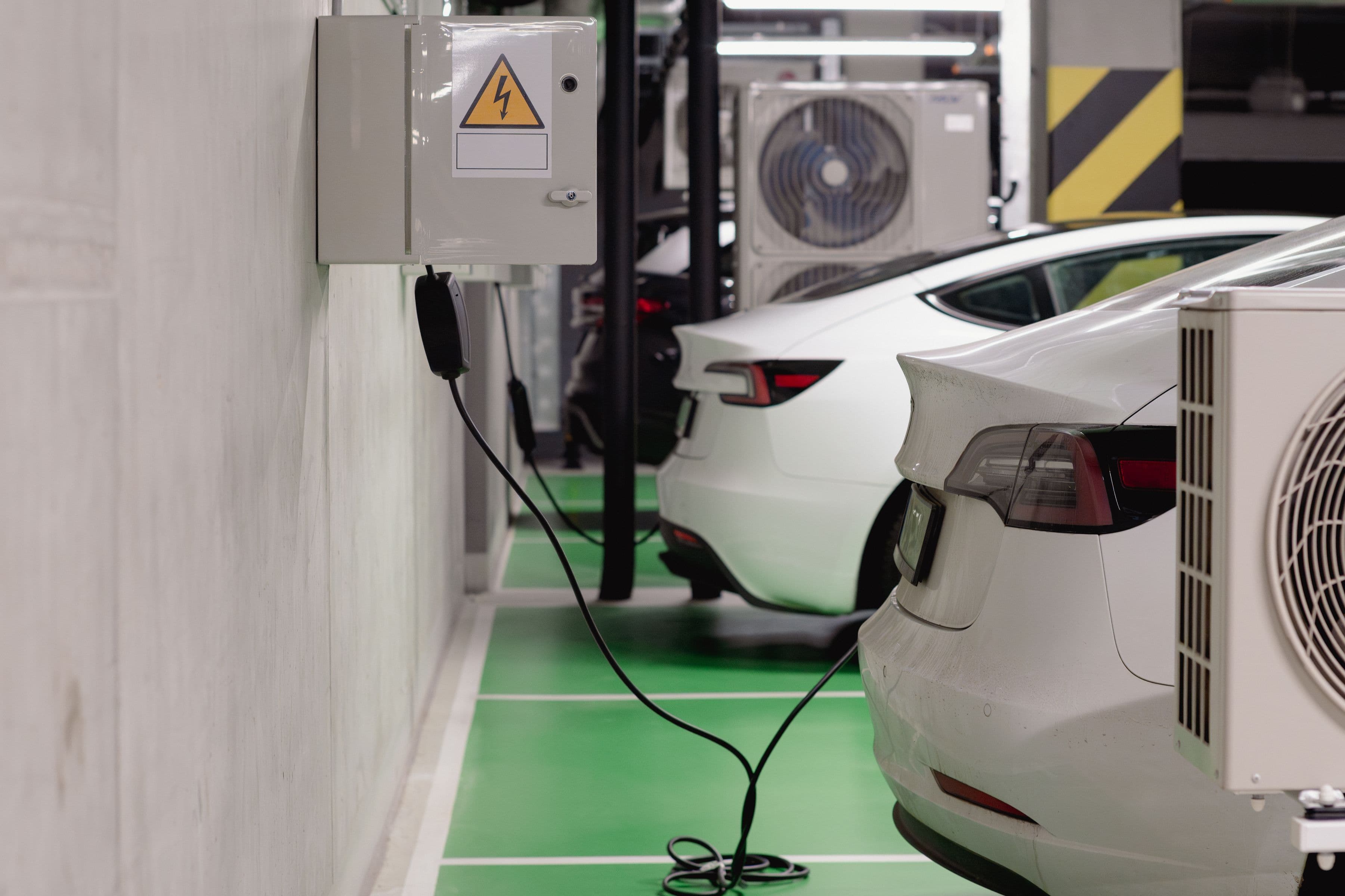Veículos elétricos a carregar numa garagem subterrânea moderna